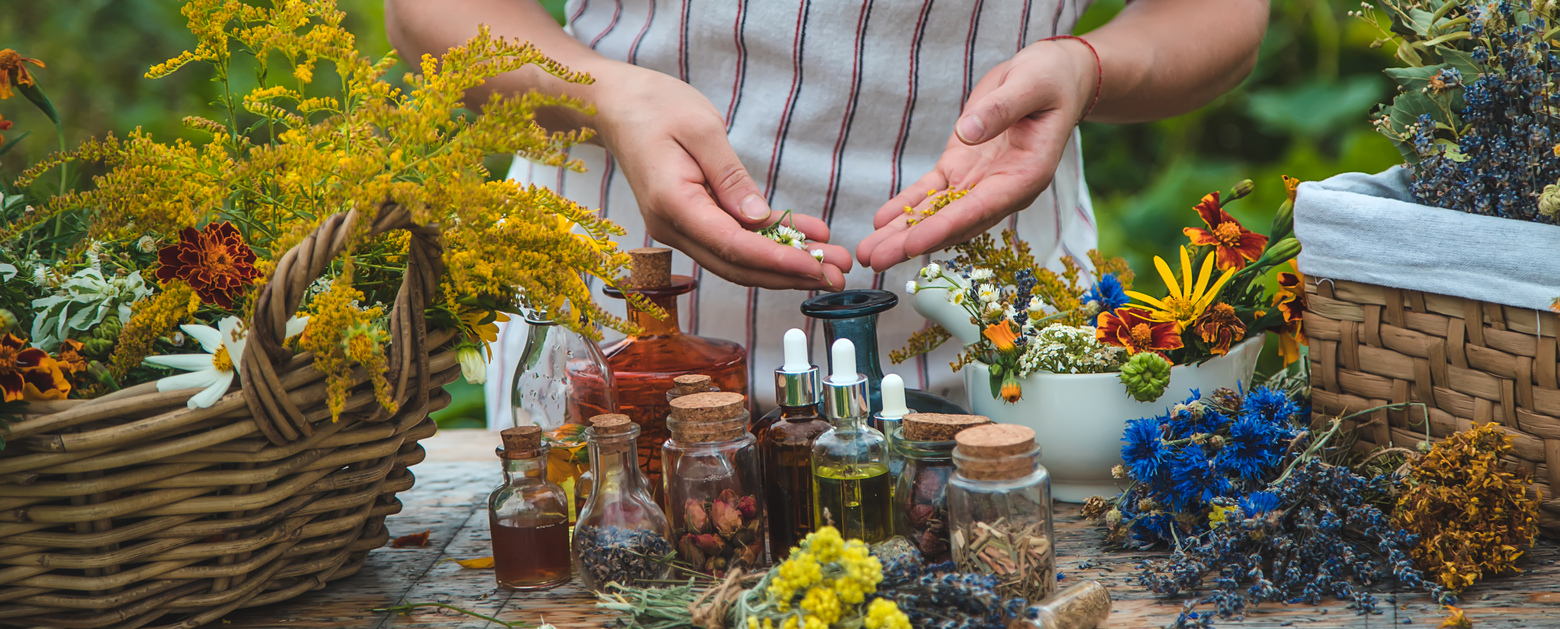 Frascos de aceites esenciales, difusor y flores aromáticas en una mesa, mostrando cómo integrarlos en la rutina diaria